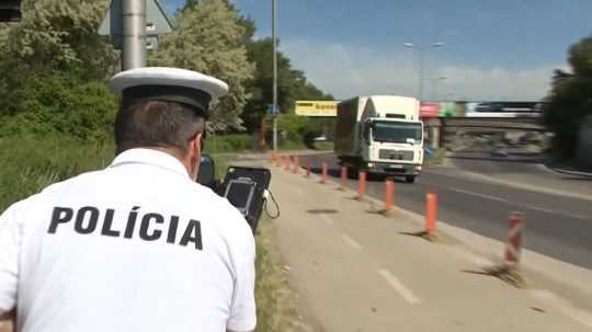 Na snímke policajt meria rýchlosť.