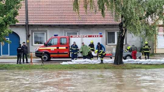 Hasiči pomáhajú obci Sobotište zvládnuť povodeň napĺňaním vriec pieskom.