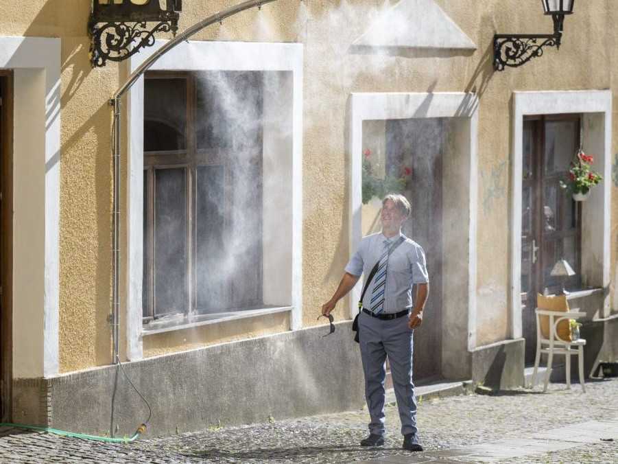 Muž prechádza cez vodnú hmlu počas horúčav v Prešove.