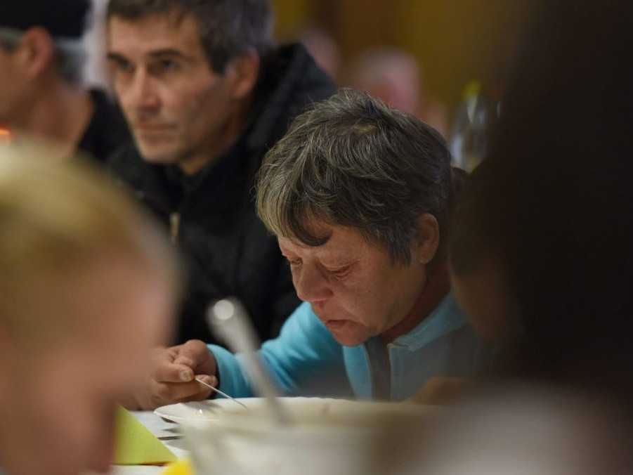 Ľudia bez domova počas charitatívnej vianočnej večere.