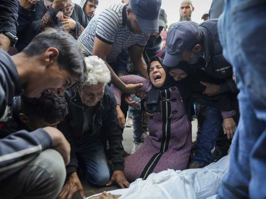 Palestínčania oplakávajú svojich príbuzných zabitých pri izraelskom bombardovaní Pásma Gazy.