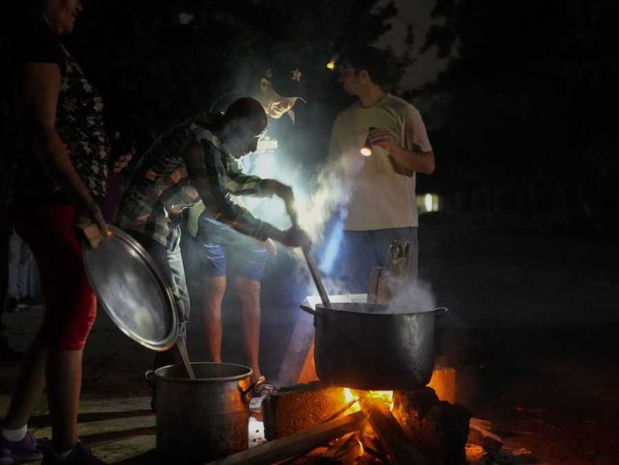 Na snímke ľudia počas výpadku elektriny počas hurikánu Oscar.