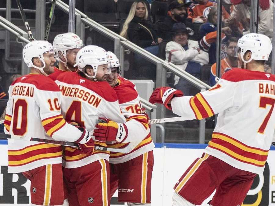 Slovenský hokejový útočník Martin Pospíšil (druhý sprava) z Calgary Flames sa teší so spoluhráčmi po strelení gólu v zápase zámorskej NHL Edmonton Oilers - Calgary Flames.