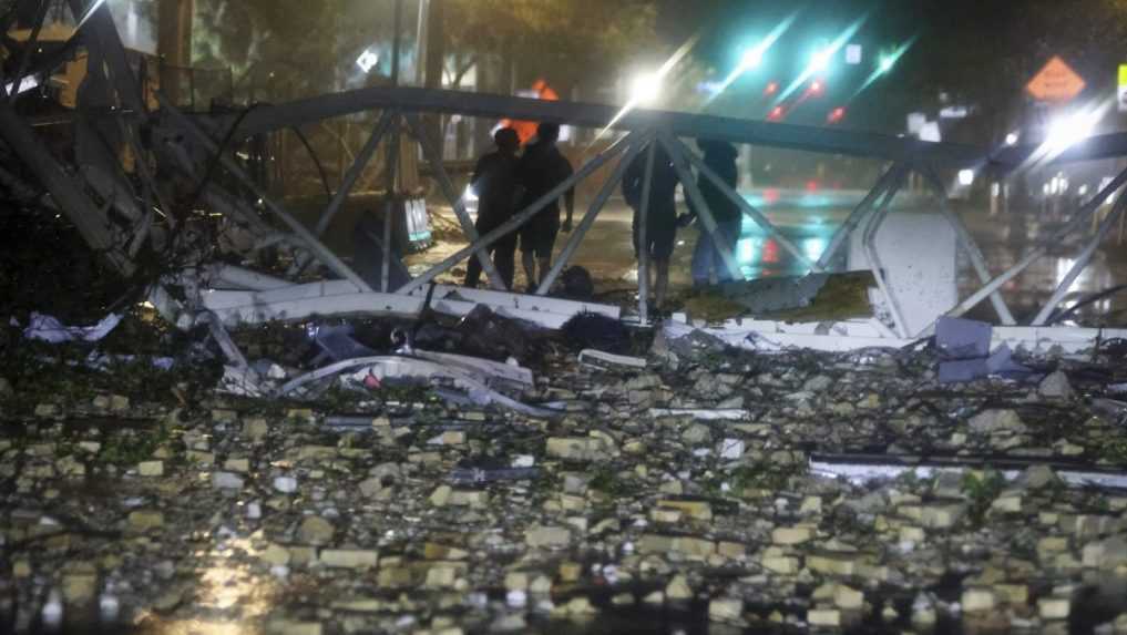 Skupina ľud&iacute; pri spadnutom žeriave na 1st Avenue South neďaleko redakcie denn&iacute;ka Tampa Bay Times.