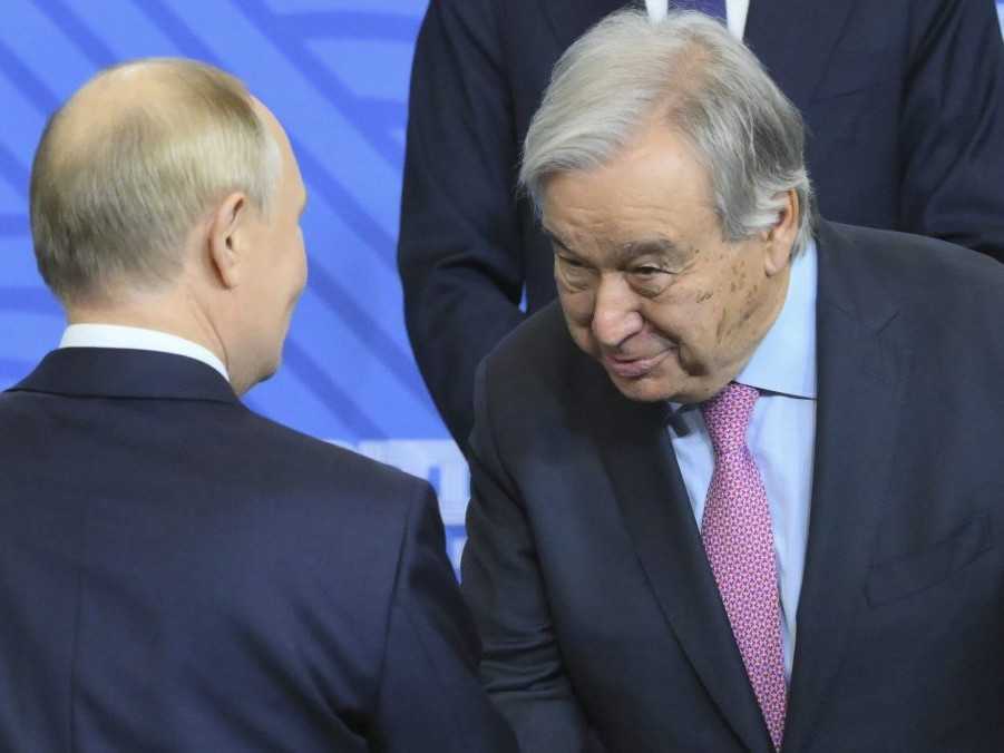 Ruský prezident Vladimir Putin (vľavo) a generálny tajomník OSN António Guterres si podávajú ruky.