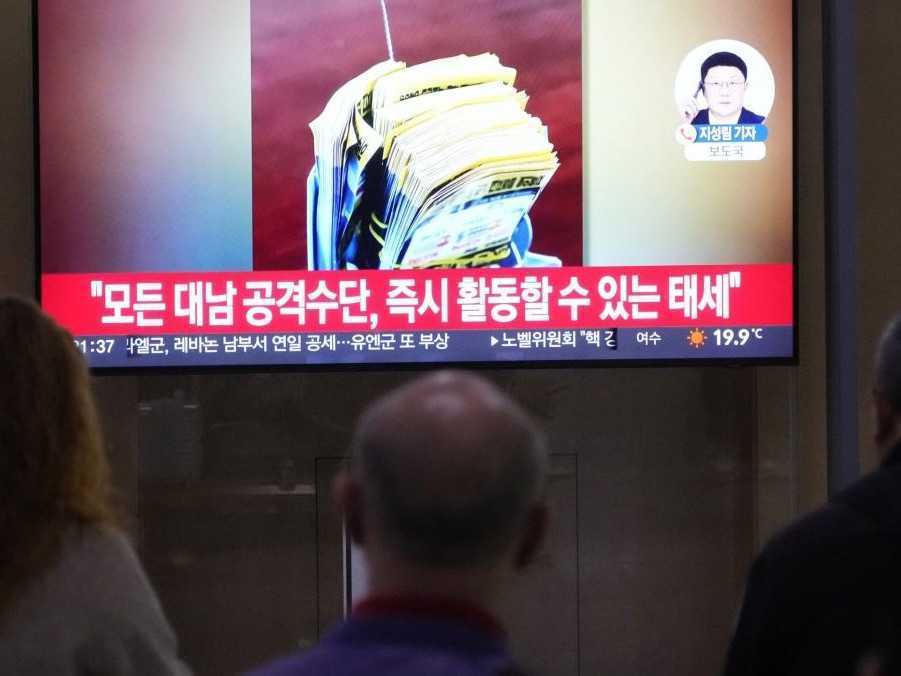 Ľudia sledujú protiseverokórejskú propagandu na železničnej stanici v Soule.