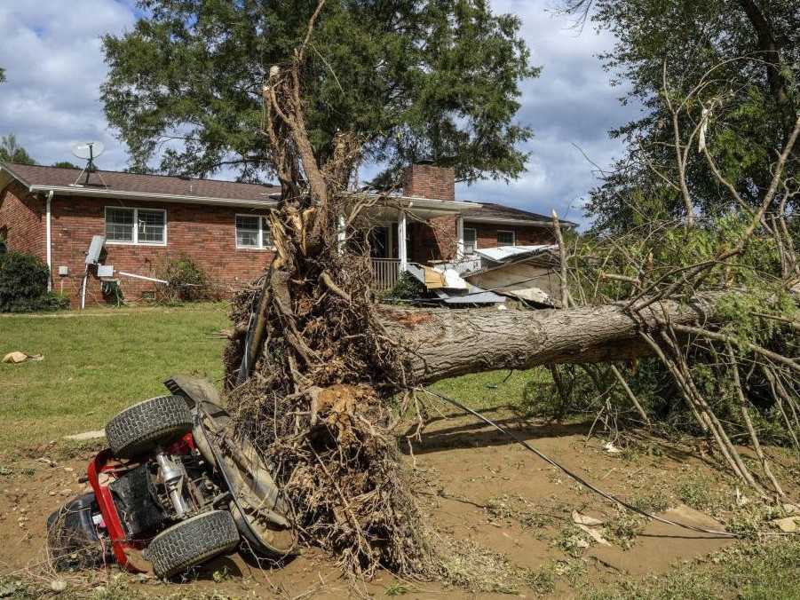 Vyvrátený strom a prevrátený traktor v dôsledku hurikánu Helene.