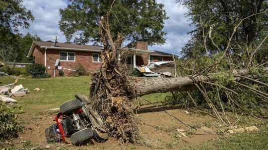 Vyvrátený strom a prevrátený traktor v dôsledku hurikánu Helene.