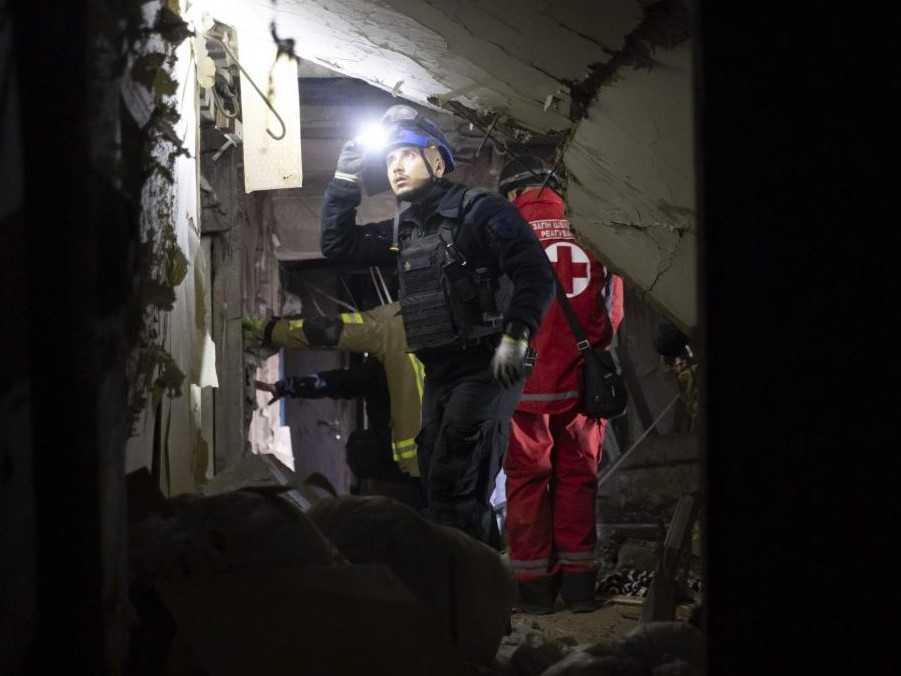 Na archívnej snímke záchranári zasahujú v poškodenej budove v Charkove.