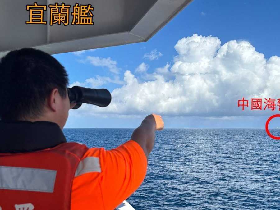 Príslušník taiwanskej pobrežnej stráže ukazuje na loď čínskej pobrežnej stráže.