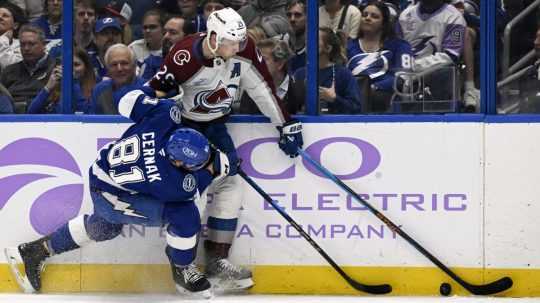 Slovenský hokejista v drese Tampy Bay Lightning Erik Černák (vľavo) a hráč Colorada Avalanche Nathan MacKinnon bojujú o puk.