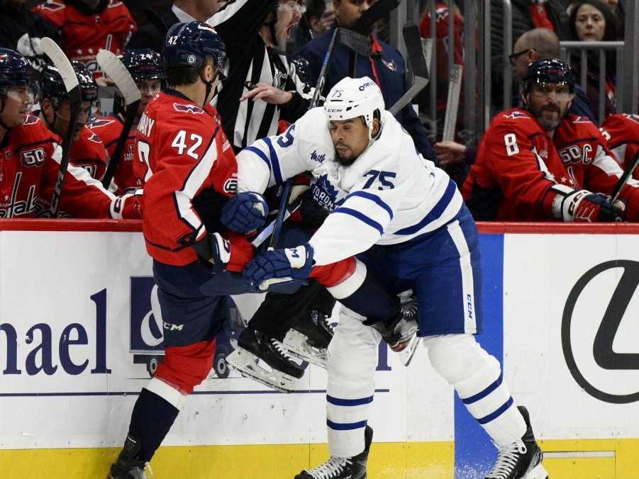 Slovenský hokejista v drese Washingtonu Capitals Martin Fehérváry (vľavo) a hráč Toronta Maple Leafs Ryan Reaves.