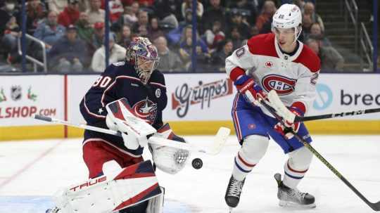 Slovenský útočník Juraj Slafkovský v drese Montreal Canadiens a brankár Columbus Blue Jackets Elvis Merzlikins.