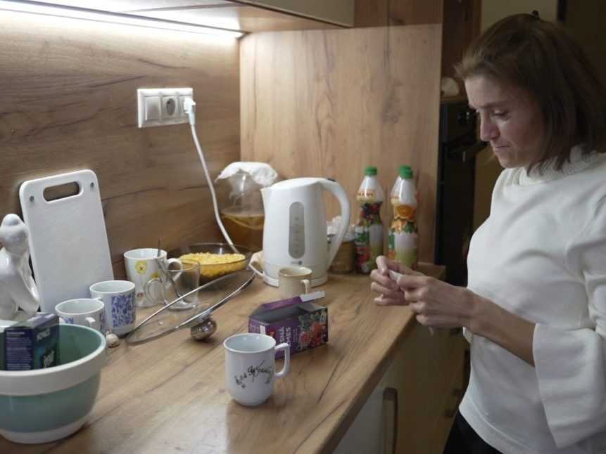 Klientka charity pani Martina robí čaj vo svojej kuchyni.