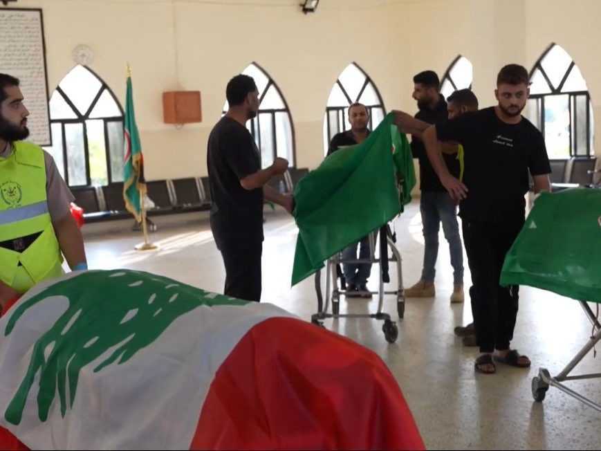 Na snímke telá zosnulých prikryté libanonskou vlajkou.