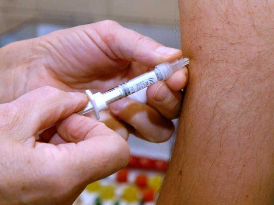 Osoba dostáva očkovanie proti chrípke.