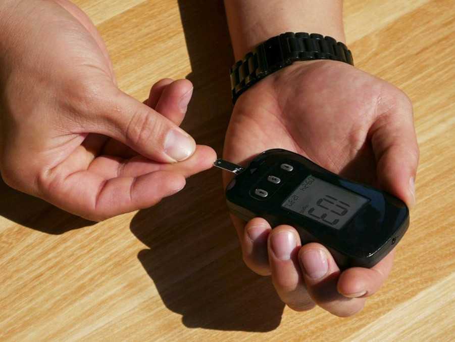 Ilustračná snímka muža kontrolujúceho si hladinu cukru v krvi.