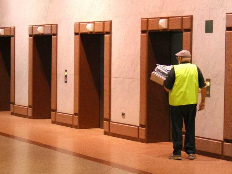 Kuriér s balíkmi v náručí.