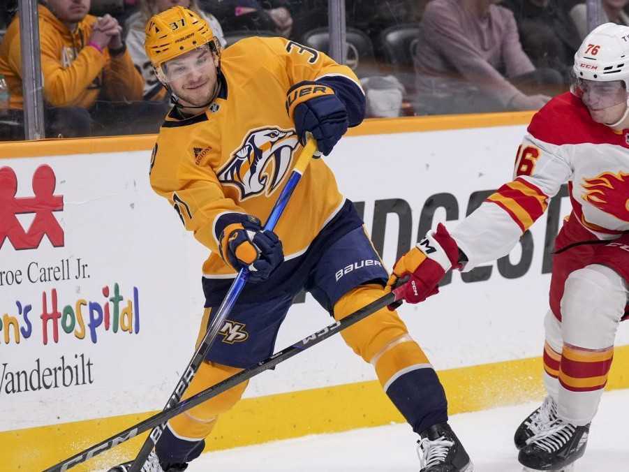 Slovenský hokejista v drese Calgary Flames Martin Pospíšil (vpravo) a hráč Nashville Predators Nick Blankenburg.