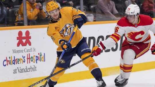 Slovenský hokejista v drese Calgary Flames Martin Pospíšil (vpravo) a hráč Nashville Predators Nick Blankenburg.