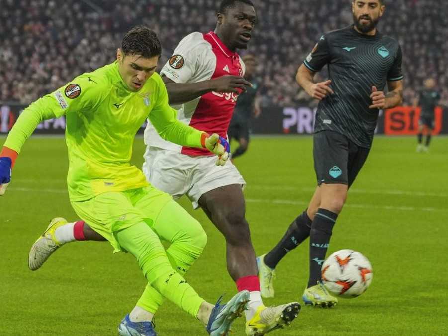 Hráč Ajaxu Kenneth Taylor (vľavo) padá vedľa Louma Tchaounu z Lazia.