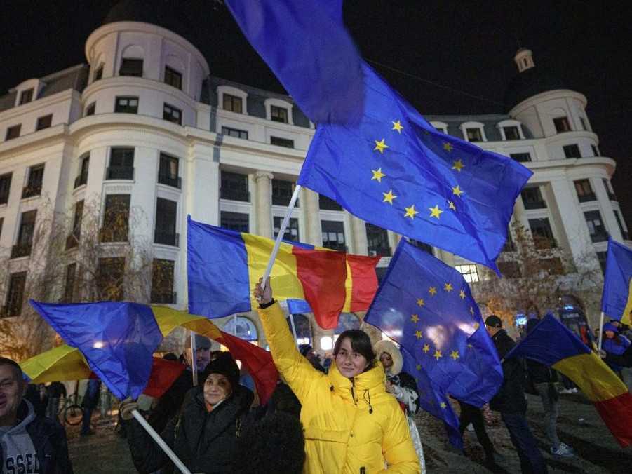 Ľudia mávajú vlajkami Rumunska a Európskej únie počas proeurópskeho zhromaždenia.