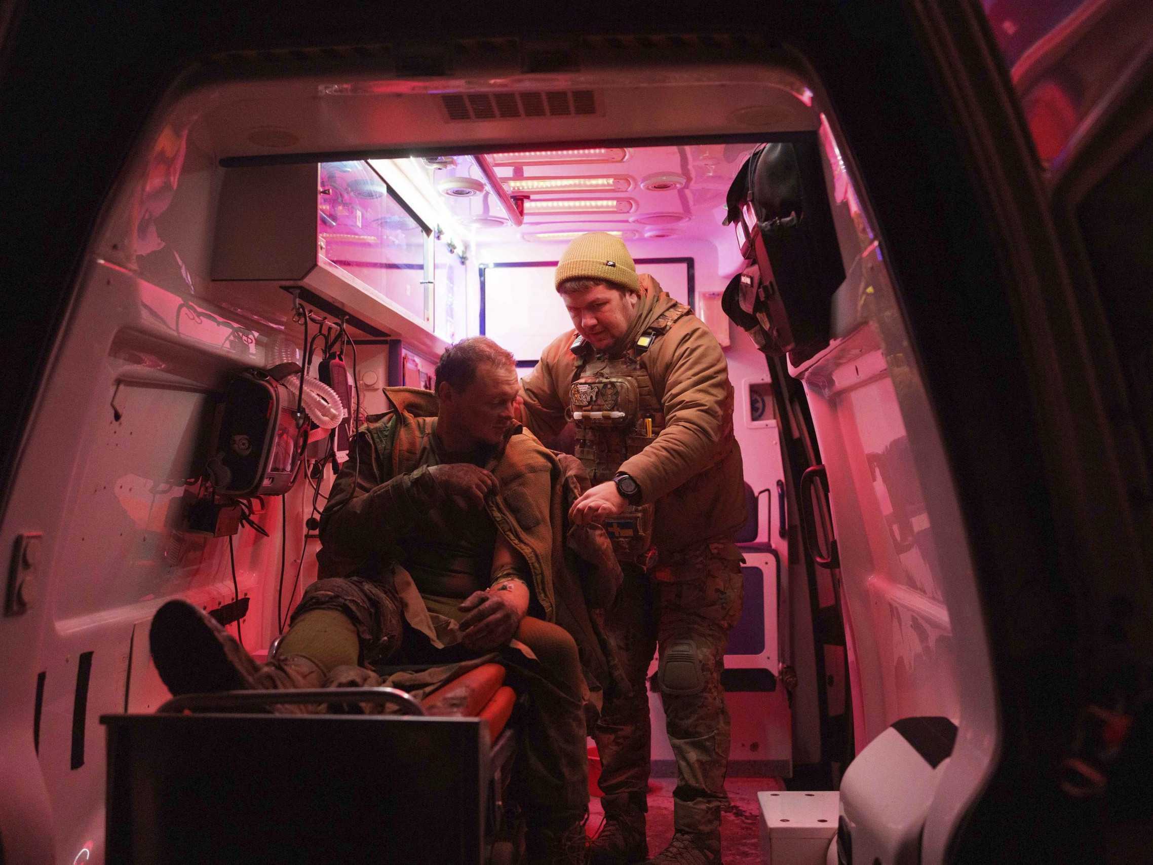 Zdravotník pomáha zranenému ukrajinskému vojakovi.