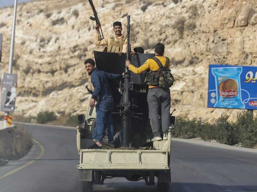 Sýrski opoziční bojovníci jazdia na diaľnici v Damasku.