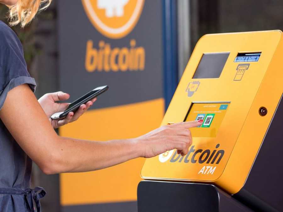 Žena pracuje s automatom na investovanie do Bitcoinu.