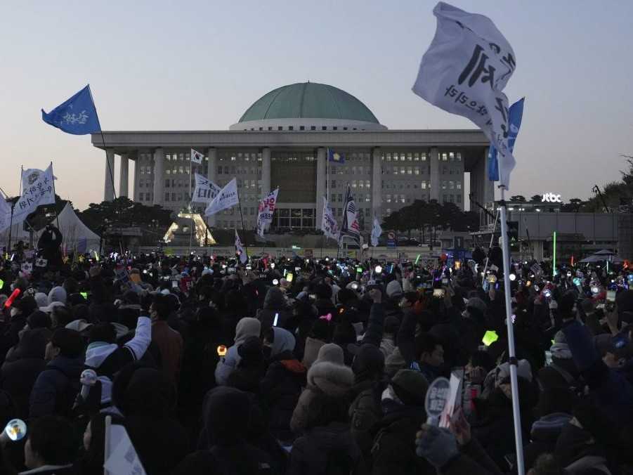 Ľudia pred juhokórejským parlamentom oslavujú odvolanie prezidenta.