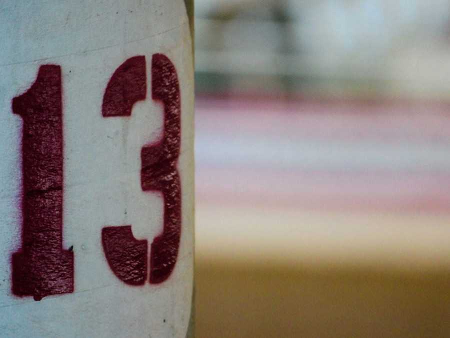 Pouličná lampa, na ktorej je nasprejované číslo trinásť.