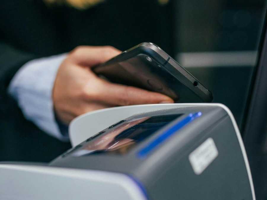 Na ilustračnej snímke žena platí mobilom.