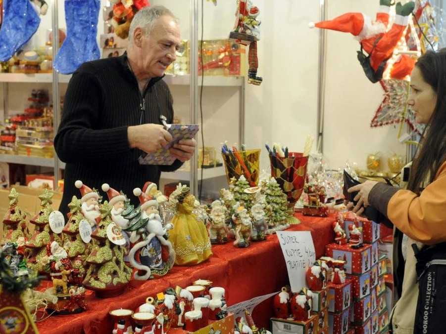 Žena pri stánku s vianočným sortimentom.