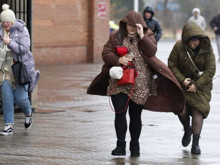 Na ilustračnej snímke ľudia kráčajú v silnom vetre.