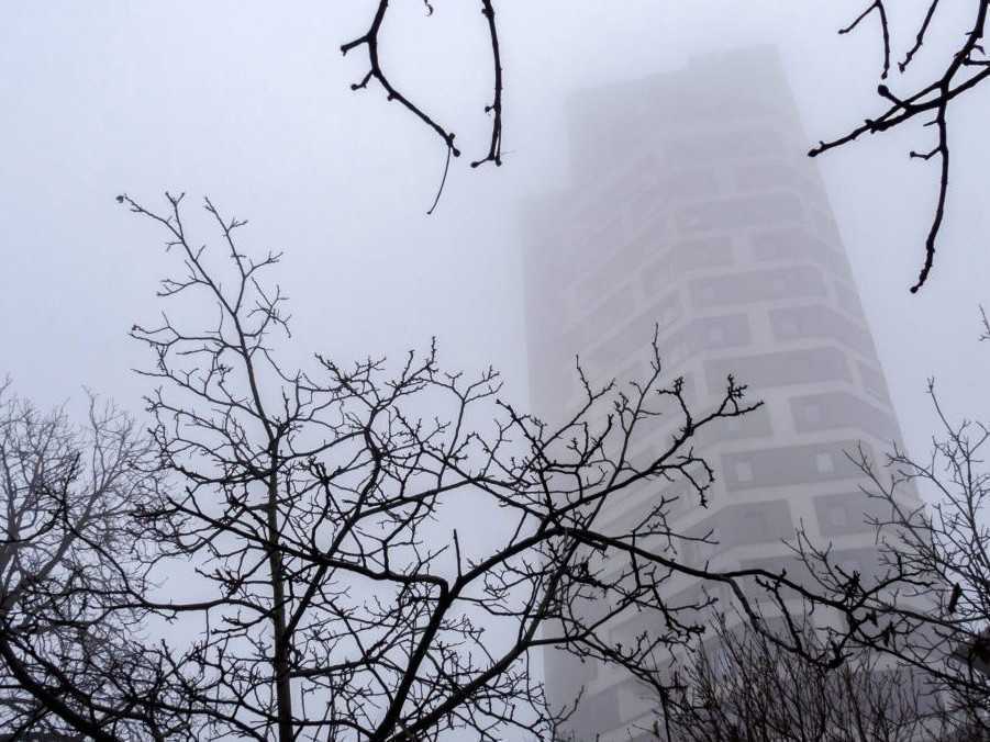 Pohľad na výškovú budovu počas hmlistého počasia v Bratislave.