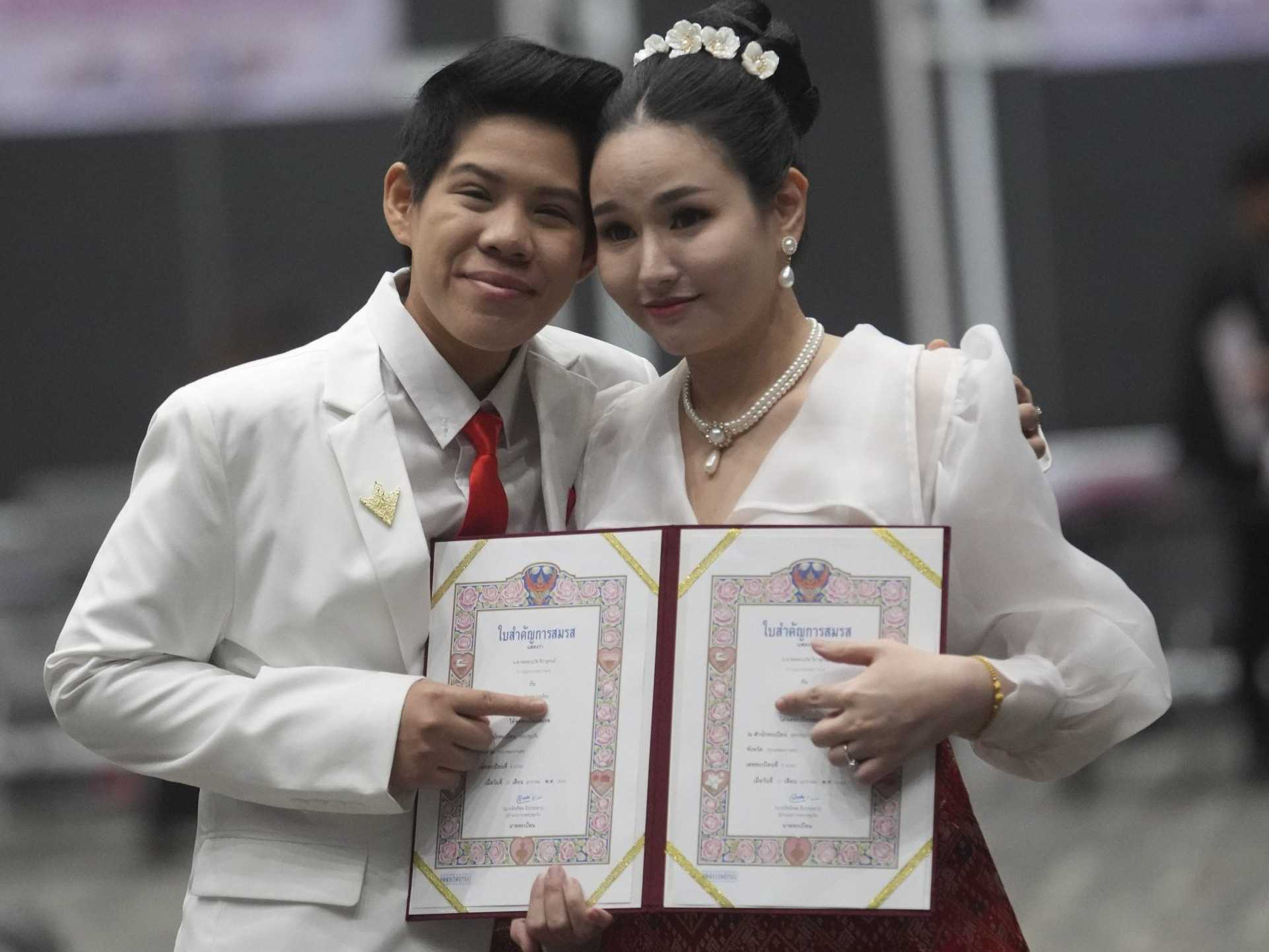 Kwanporn Kongpetch (vľavo) a Ploynaplus Chirasukon ukazujú svoje sobášne listy po tom, ako vstúpil do platnosti zákon o manželskej rovnosti v thajskom Bangkoku.