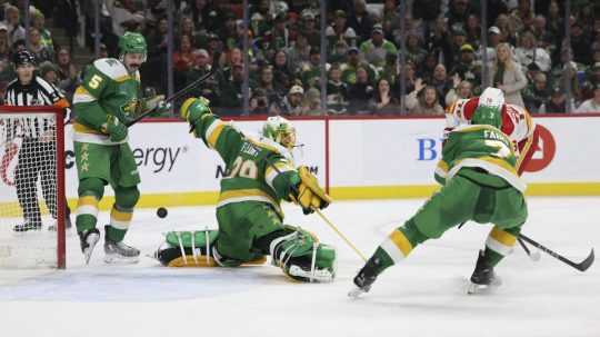 Snímka zo zápasu Minnesota Wild vs. Calgary Flames. Vpravo slovenský hokejista Martin Pospíšil.