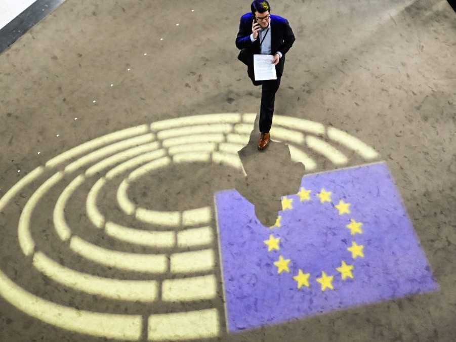 Muž prechádza popri Európskom parlamente.