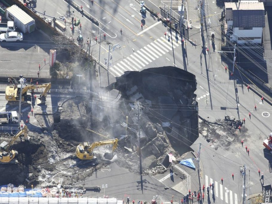 Na snímke záchranári pri prepadline na ceste v Japonsku.