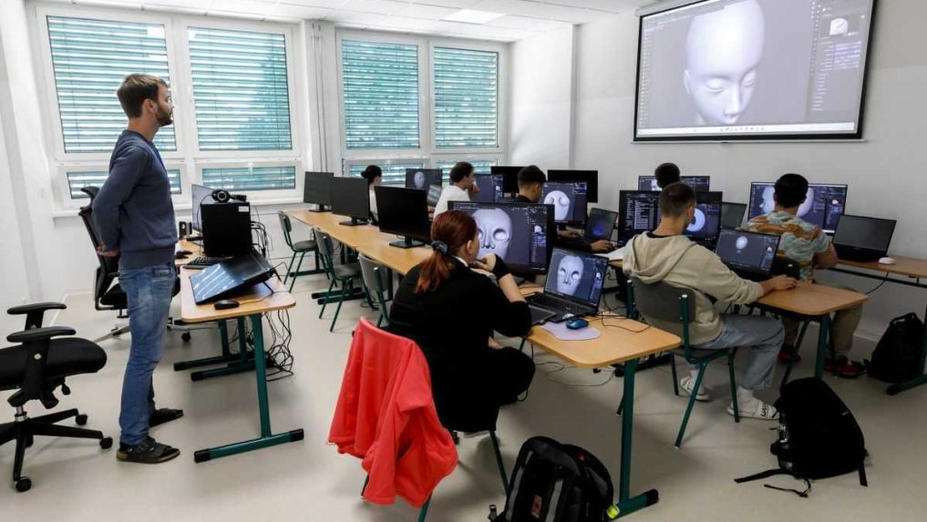 Na ilustračnej snímke učiteľ a študenti v triede.