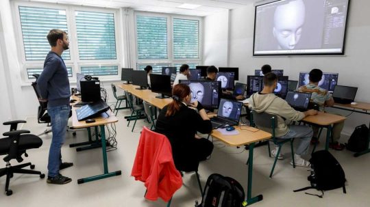 Na ilustračnej snímke učiteľ a študenti v triede.