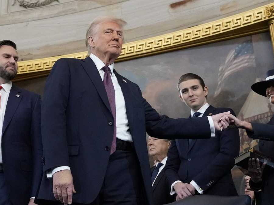 Prezident Donald Trump (uprostred) drží svoju manželku Melaniu Trumpovú (vpravo) za ruku a ich syn Barron Trump a viceprezident JD Vance (vľavo).