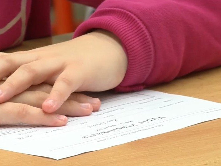 Na ilustračnej snímke dieťa s vysvedčením.