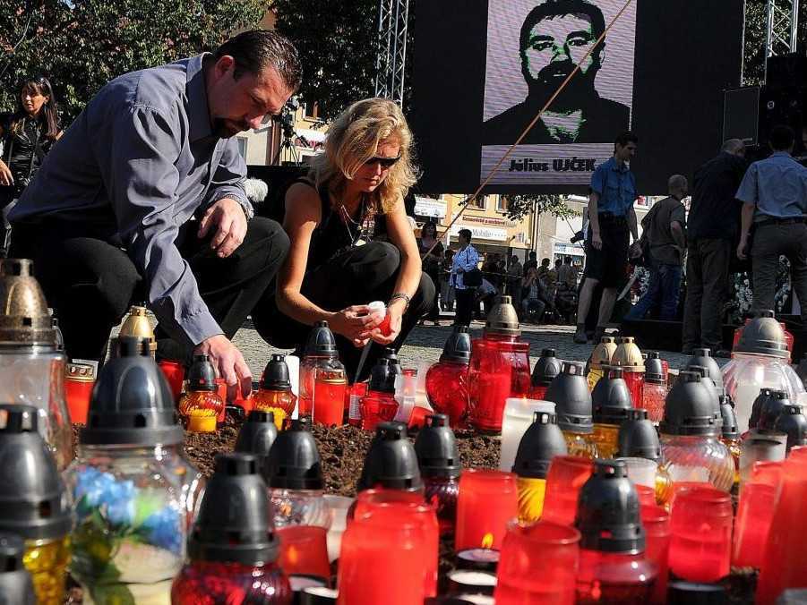 Na archívnej snímke ľudia zapaľujú sviečky na rozlúčke s obeťami baníckeho nešťastia v Handlovej v auguste 2009.