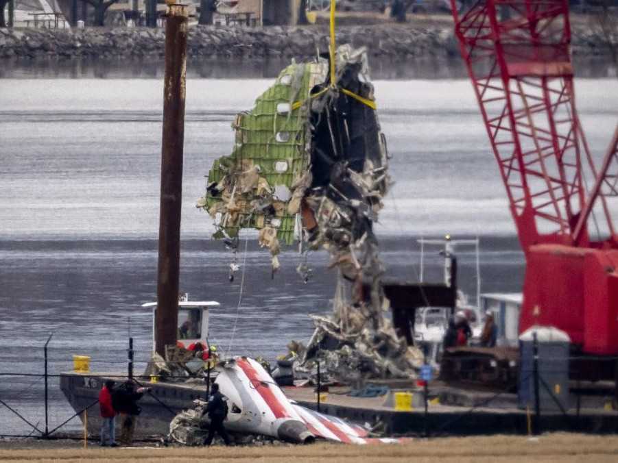 Žeriav vykladá kus vraku lietadla.