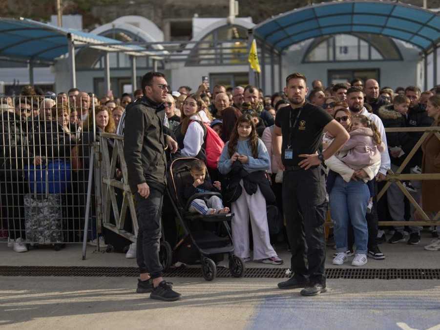 Cestujúci čakajú na príchod trajektu v Grécku.