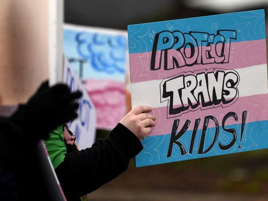 Osoba drží nápis počas protestu za práva transrodových osôb.