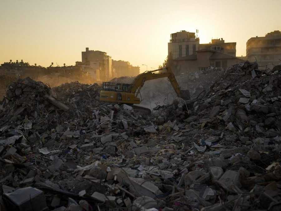 Bager odpratáva sutiny budov po ničivom zemetrasení v Turecku.