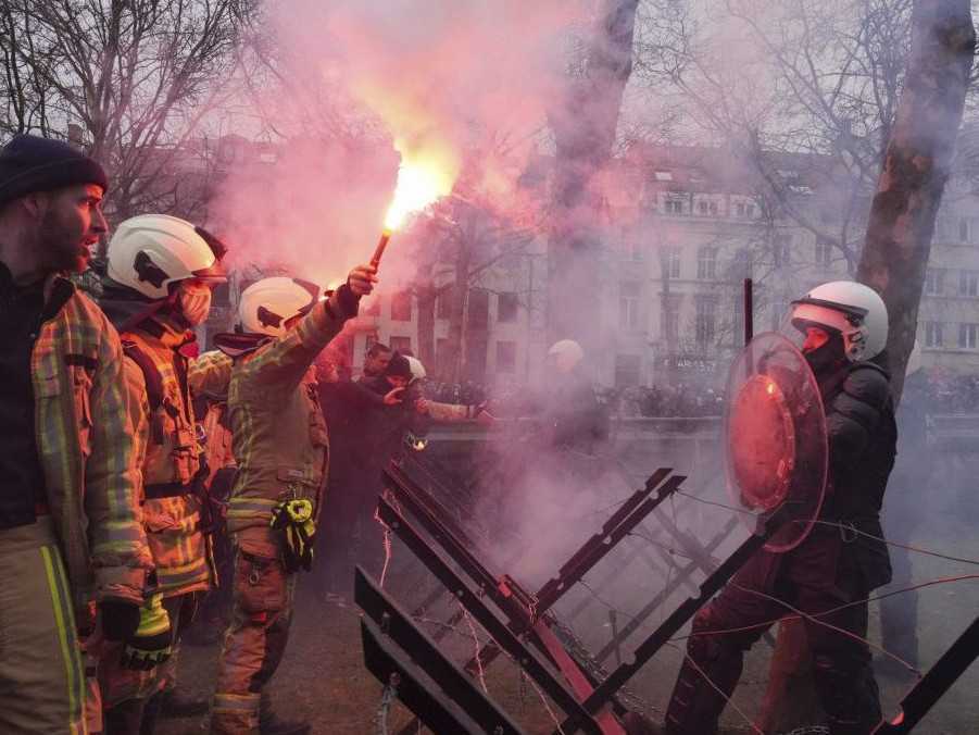 Na snímke hasiči so zapálenými svetlicami.