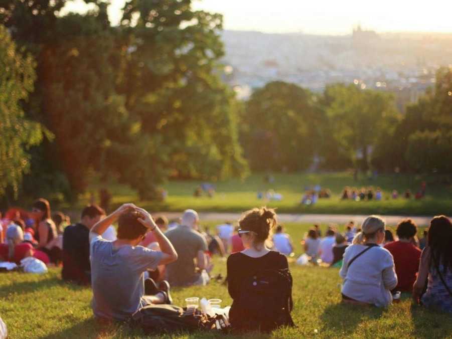 Na snímke mladí ľudia sediaci v parku.